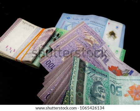Bundle of money. Malaysia Ringgit (MYR) RM100, RM50, RM5, RM1 with isolated black background