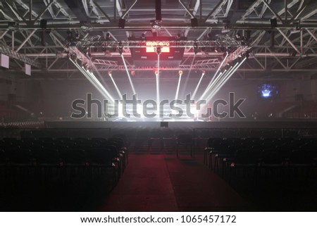 Empty boxing ring in the light of searchlights, around it the empty seats of the auditorium.