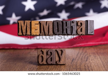 Closeup of a Memorial Day wooden banner with the American flag in background