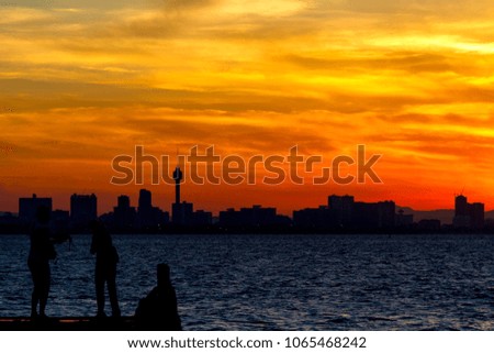 silhouette of couple taking photo at the port with beautiful sunset
