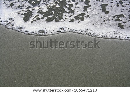Sea water wave and black sand in Limassol beach, Cyprus