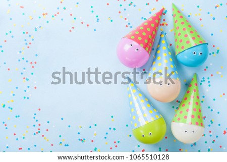 Colorful balloons and confetti on blue table top view. Birthday or party background. Flat lay. Greeting card. 