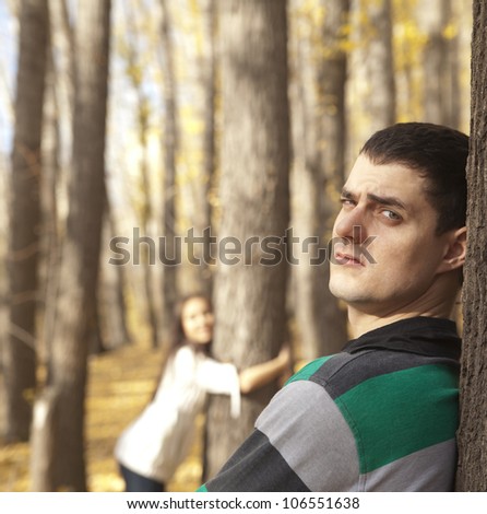 A picture of a young couple standing in the park and being in a conflict