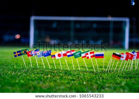 Football ball on green grass and all national flags  Royalty-Free Stock Photo #1065543233