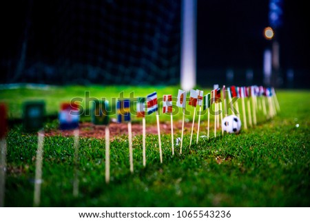 Football ball on green grass and all national flags  Royalty-Free Stock Photo #1065543236
