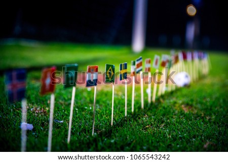 Football ball on green grass and all national flags Royalty-Free Stock Photo #1065543242