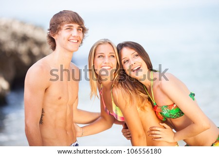three young beautiful friends having fun on the beach