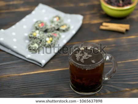 A cup with herbal tea and cookies on a dark background.