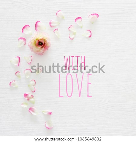 Image of delicate pastel pink beautiful flowers arrangement over white wooden background. Flat lay, top view