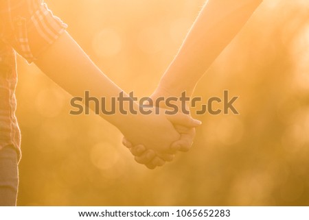 I love you! Love is in the air. Boy is holding girls hand in beautiful warm sunset light. Love between people. Relationship goals, two young people in love. Live and walking together. 