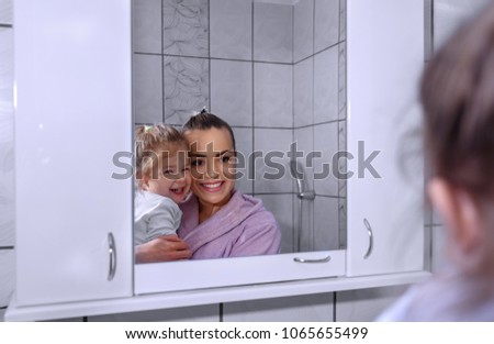 Happy loving family. Mother and her daughter child girl kissing and hugging in bathroom at home

