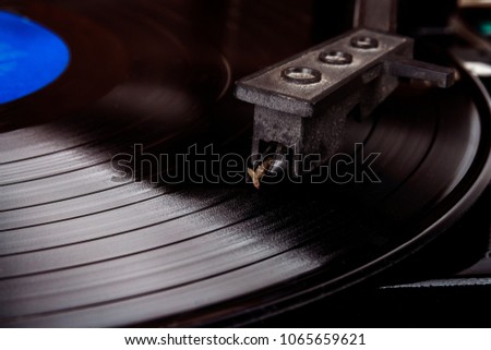 Turntable stylus on a vinyl record. Vintage vinyl record player. Needle on a black vinyl record.