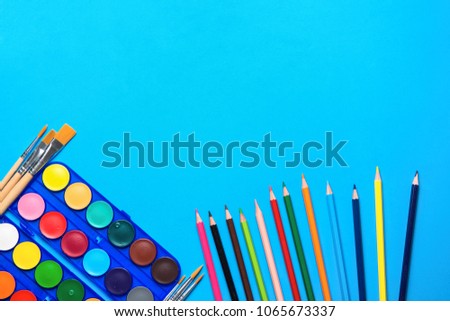 Palette with Rows of Multicolored Watercolor Paints Brushes Pencils on Blue Background. Arts School Class Creativity Painting Hobbies Kids Education Concept. Poster Banner Streamer Template