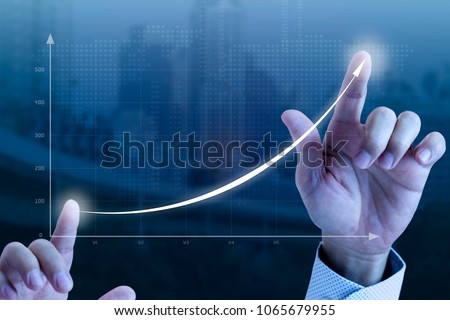 Close up of a businessmanâ??s hands drawing an exponential line curve showing of business growth and success rapidly. Royalty-Free Stock Photo #1065679955