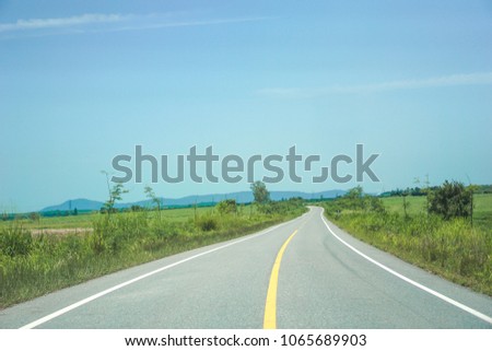 Road through green meadows, travel concepts or travel.              