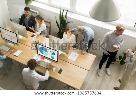 Young and senior office employees staff team talking working together, business people sharing desk using computers in coworking, mentors teach diverse interns, corporate teamwork concept, top view Royalty-Free Stock Photo #1065757604