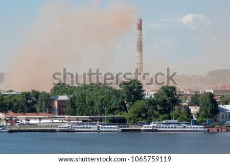 Metallurgical plant near a beautiful lake. Emission of nitrogen oxide into the atmosphere. Pollution of the environment. Royalty-Free Stock Photo #1065759119