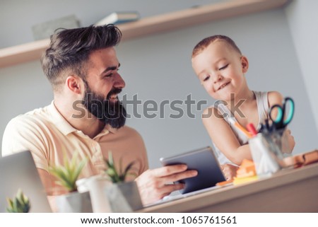 Father and son using tablet together,having great time together.