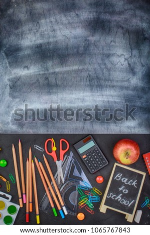 School supplies on black board background colorful september