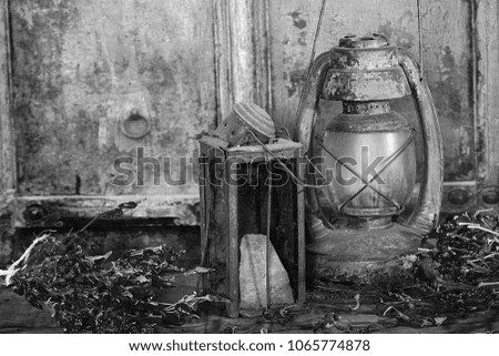 Old oil lamps with chilli pepper bunts on an antique background .. Black and white photography