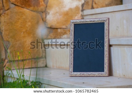photo frame on a stone staircase. Black billboard. Mock up.