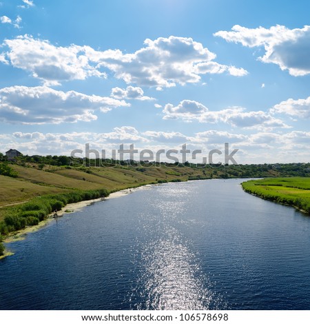 view to river with reflections and blue cloudy sky Royalty-Free Stock Photo #106578698