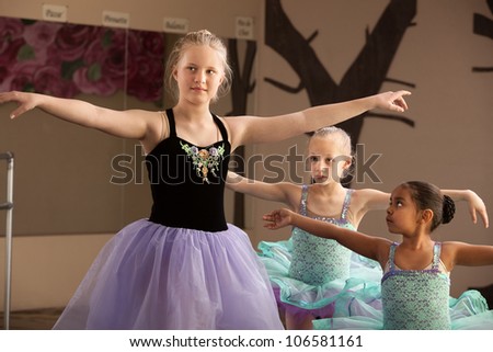 Young ballet students of different ages practicing together