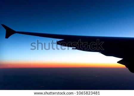 Silhouette plane wings sunrise at the skyline picture from the plane