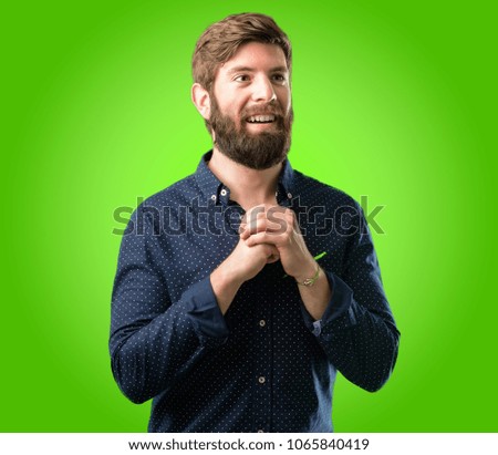 Young hipster man with big beard confident and happy with a big natural smile in love over green background