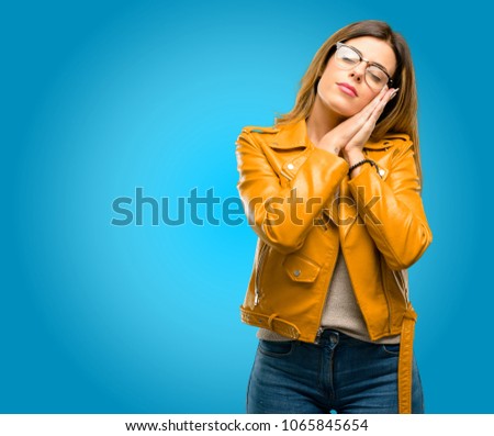 Beautiful young woman tired and bored, tired because of a long day overworking, blue background