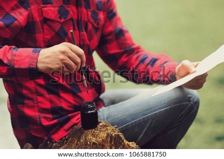 Adventurer in red checkered shirt drawing a map in search of a lost treasure. Pirates love story date. Man making the map older.