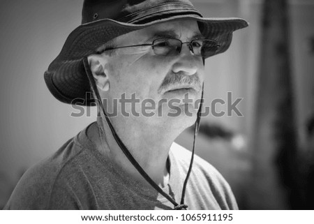 Black and white senior male with hat and glasses outdoors