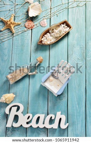 summer background with top view of beach accessories and letters on blue wooden board 