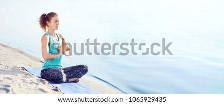 Wide picture of a woman meditating at the beach