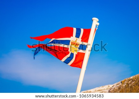 Outdoor view of Norwegian flag waving with a beautiful blue sky background