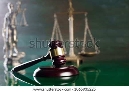 Judge's gavel on green background.