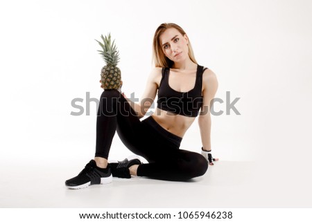 Fitness girl with pineapple on white background