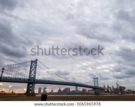 Panoramic view of the Ben Franklin Bridge as seen from Camden, NJ. The Philly Skyline is seen beyond as cool gray clouds fly above