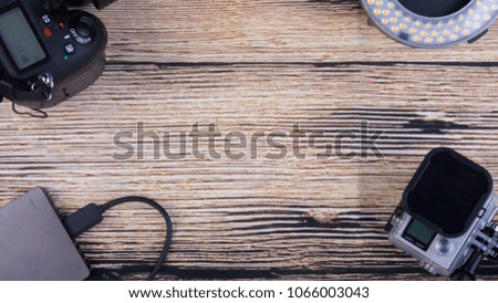 Conceptual image of Holidays Concept with camera, media storage, tablet and watch, action camera, bank notes on a wooden background. Selective focus and crop fragment.