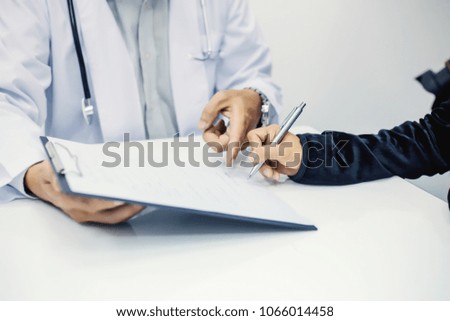 Doctor handed pen to patients to sign the signed.  Signed consent for surgery