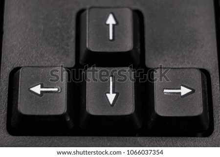 An enlarged computer keyboard. Black keyboard buttons for the computer. Dark background.