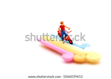Miniature people : children cycling on Colorful of candies and lollipops,Food enjoy concept.