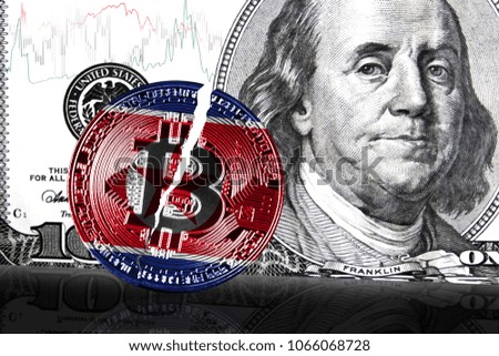Cracked coin bitcoin with the flag of North Korea, in the background a dollar usa banknote with a graph of the course of the fall
