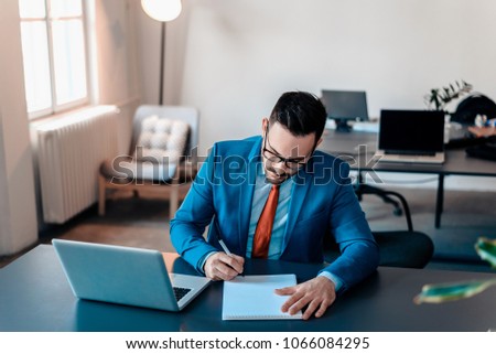 Busy businessman writing notes on paper.