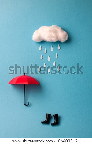 umbrella and rain boots under the cloud on sky blue background