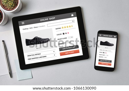 Online shop concept on tablet and smartphone screen over gray table. All screen content is designed by me. Flat lay Royalty-Free Stock Photo #1066130090