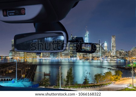 Looking through a dashcam car camera installed on a windshield with view of Manhattan skyline at night, New York City, USA