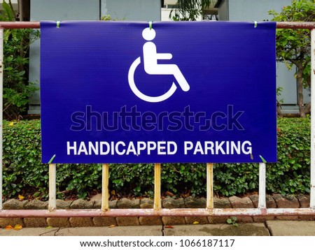 blue handicapped parking sign showing wear.