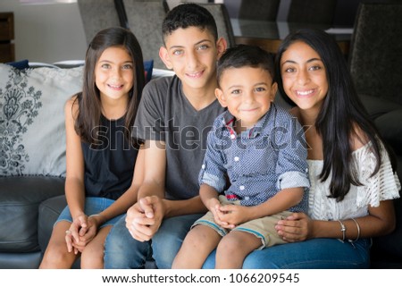 Smiling siblings in the living room.
Two brothers and two sisters sitting on the couch smiling.
 Royalty-Free Stock Photo #1066209545