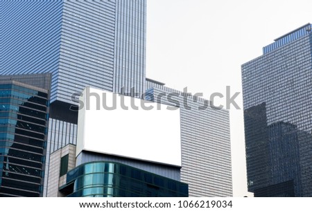 Blank advertising billboard, lcd screen television on top of modern building in the city sky background useful for products advertisement, mock up image